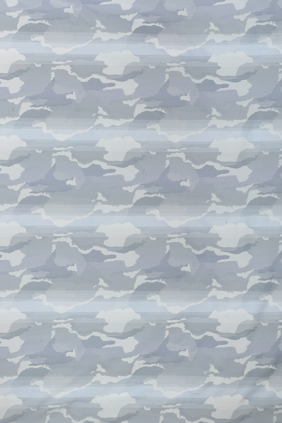 The image showcases a close-up of a light grey and white camouflage pattern, abstractly resembling cloud formations or geographical contours.