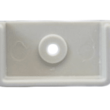 A rectangular, light-colored plastic object with a central hole. It appears to be a component or part, possibly for mounting or attaching.